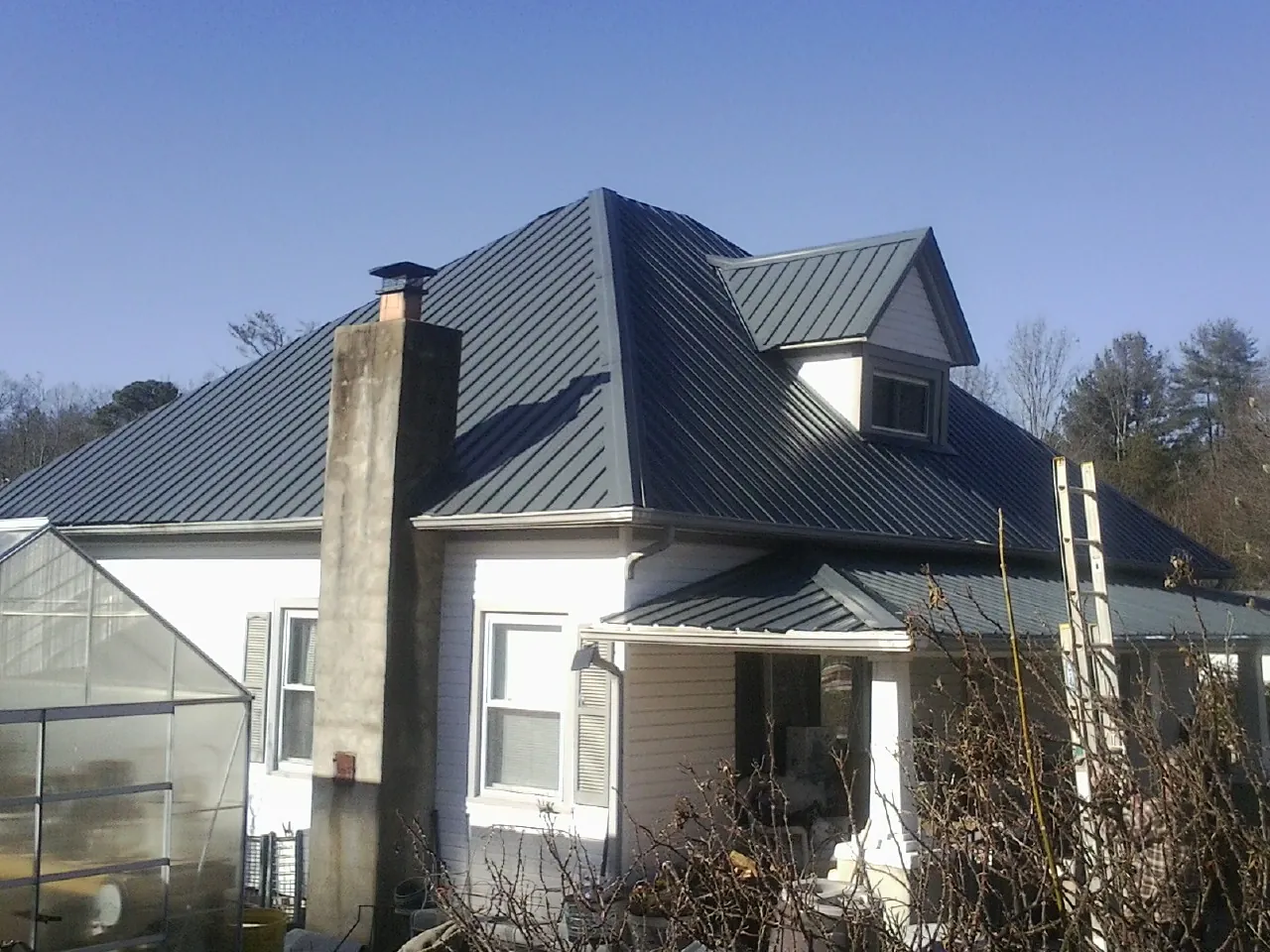 Dark blue standing seam metal roof on a white farmhouse with dormer — Slate & Tile Roof Repair by Roofing Brothers in Pauma Valley