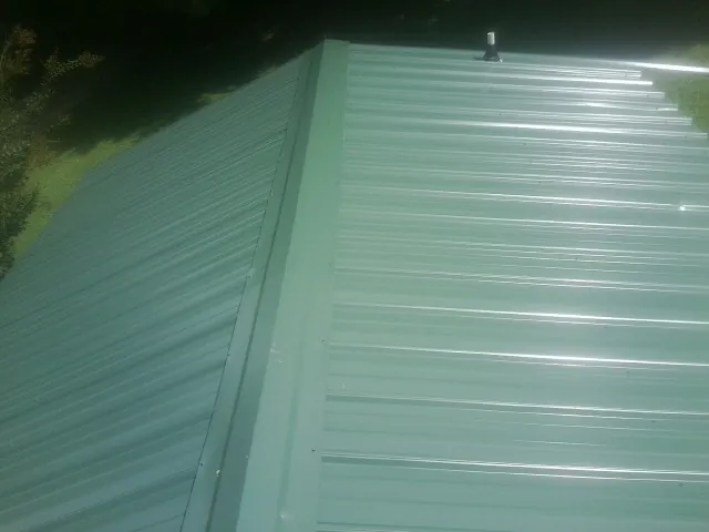 New green metal panels meeting at the ridge of a roof — Flat Roof Repair work by our crew in Pauma Valley