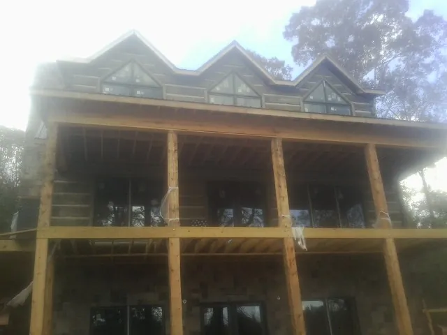 Dormers and porch framing on a large log home under construction — Roof Coating work by our crew in Pauma Valley